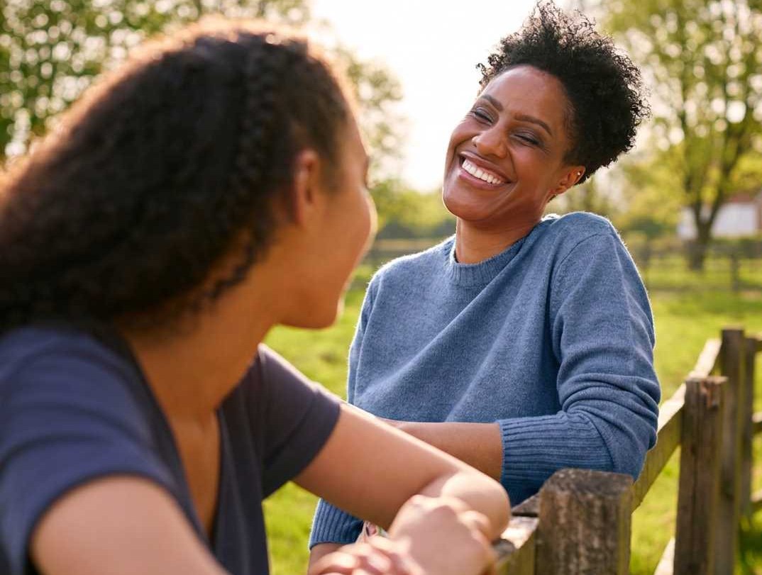 Two women talking and smiling together outdoors